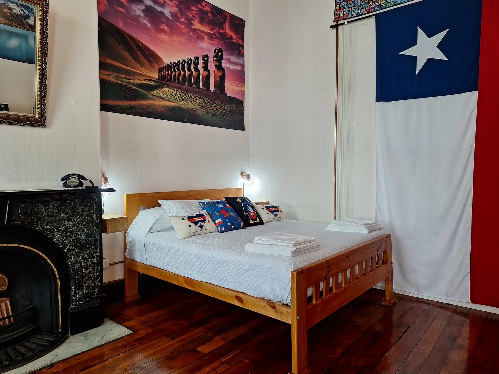 Cama junto a la bandera chilena en la habitación Chile de CasaFran