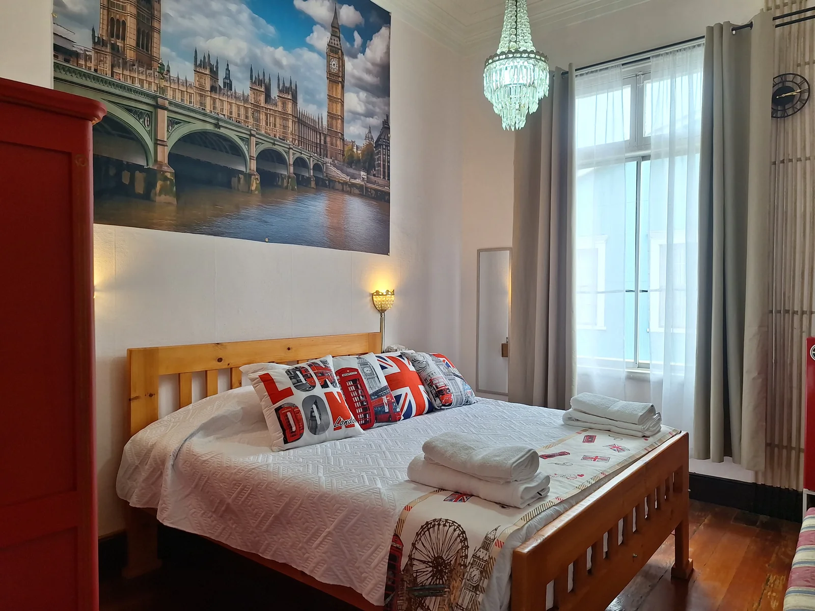 Vista general de la cama y la ventana en la habitación Inglaterra de CasaFran